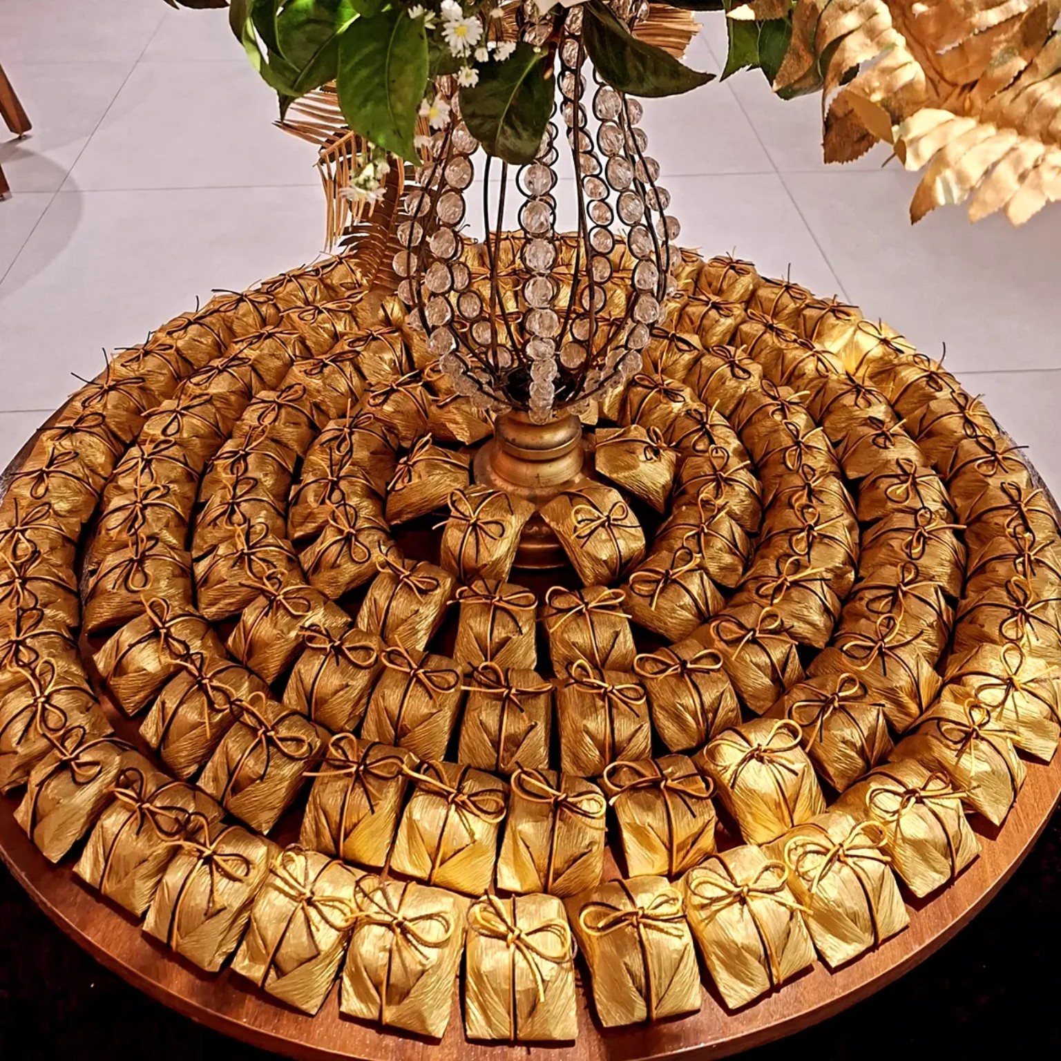Doces embalados em papel dourado com laços em uma mesa de celebração